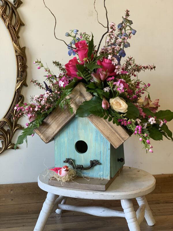 a beautiful birdhouse decorated with flowers